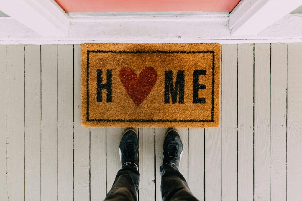 Free Airbnb Welcome Template (Printable) A creative doormat with heart motif symbolizing home at a front porch entrance.