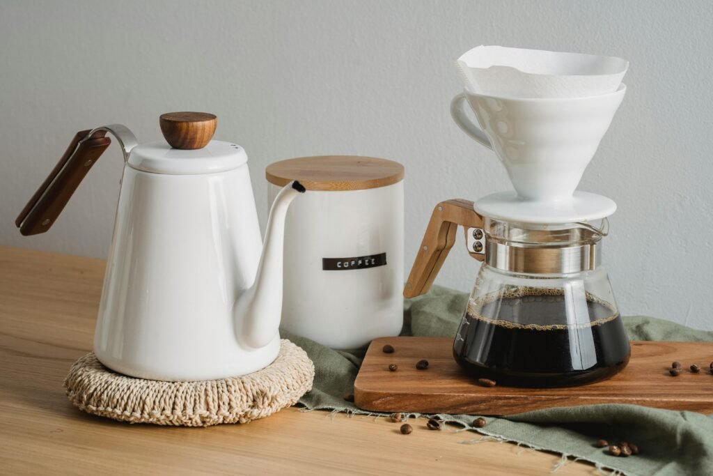 A stylish coffee brewing setup with kettle, filter, and pot on a wooden table, perfect for coffee lovers.