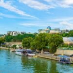 Beautiful riverside showing Tbilisi's vibrant urban architecture with ferries along the canal.