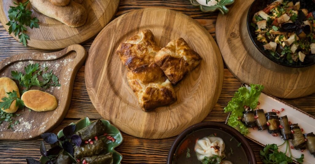 A variety of traditional Georgian dishes displayed on a wooden table with fresh herbs.